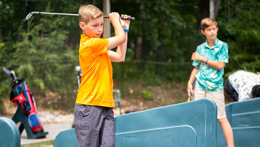 Two boys at the driving range at Massanutten Resort