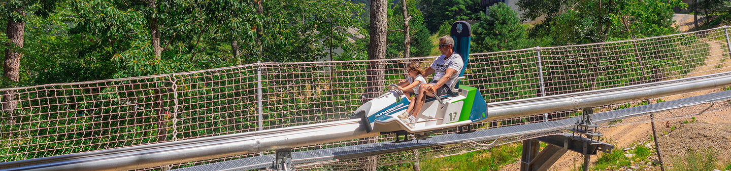 A father & daughter riding the mountain coaster at Massanutten Resort
